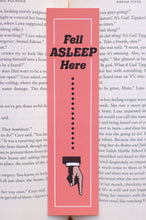 Load image into Gallery viewer, Bookmark with text &#39;Fell Asleep Here&#39; on a book page