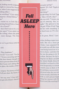 Bookmark with text 'Fell Asleep Here' on a book page
