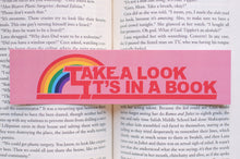 Load image into Gallery viewer, Book with a rainbow sticker reading &#39;Take a Look It&#39;s in a Book&#39; on an open book page.