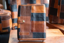 Load image into Gallery viewer, Patchwork leather notebook on a wooden surface with blurred background
