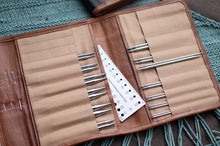 Load image into Gallery viewer, Set of knitting needles and a ruler in a brown case on a textured surface