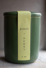 Load image into Gallery viewer, Green candle jar with a label reading &#39;pomelo + peony&#39; on a neutral background