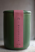 Load image into Gallery viewer, Green candle jar with a pink label on a wooden surface