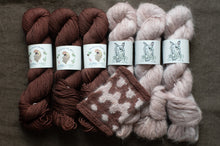 Load image into Gallery viewer, Three skeins of brown yarn and three skeins of pink yarn with matching knitted fabric on a dark background.