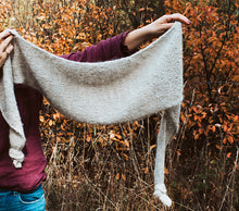 Load image into Gallery viewer, Person holding a large knitted shawl against an autumnal background