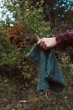 Load image into Gallery viewer, Person holding a green towel with dried plants against a natural background