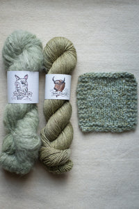 Two skeins of green yarn and a knitted swatch on a light gray background