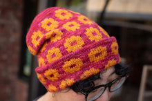 Load image into Gallery viewer, Colorful knitted beanie with pink and yellow pattern worn by a person.