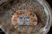 Load image into Gallery viewer, Decorative stone with sun and face design on a bed of small stones