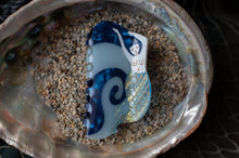 Load image into Gallery viewer, Decorative blue and white shell on a bed of small stones inside an ornate metal dish.