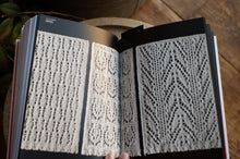 Load image into Gallery viewer, Open book displaying knitted pattern illustrations on a wooden surface