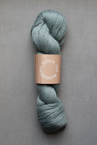 Skein of blue yarn with a label on a gray background