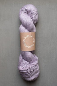 Lavender skein of yarn with a label on a gray background