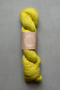 Yellow skein of yarn with a label on a gray background
