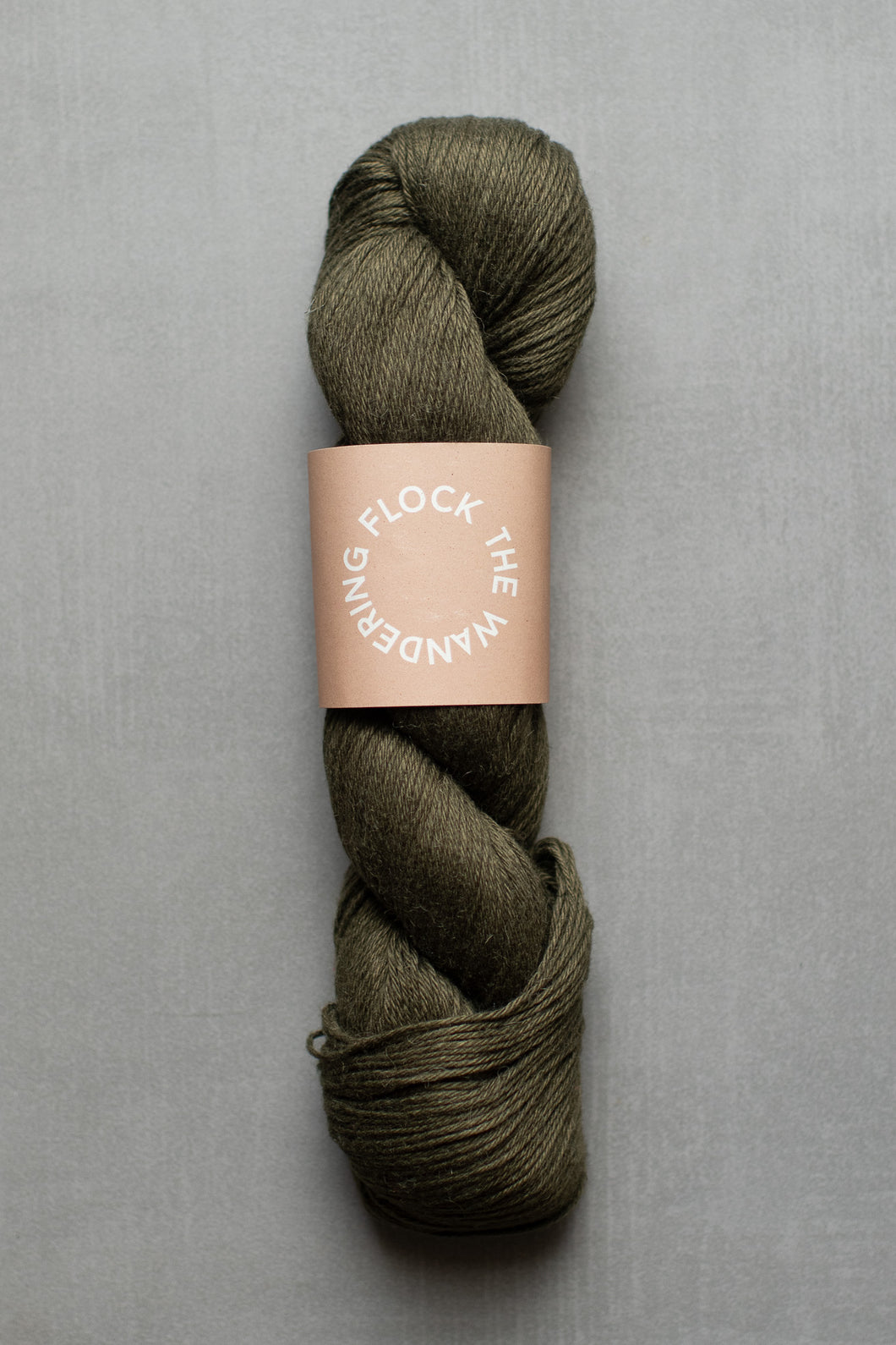 Green skein of yarn with a label on a gray background