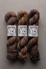 Load image into Gallery viewer, Three skeins of variegated yarn with white paper labels reading 'Dream Style Spincycle Yarns' arranged side by side on a neutral gray background.
