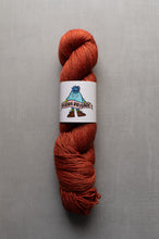 Load image into Gallery viewer, Ball of red yarn with a label on a gray background