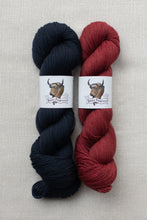 Load image into Gallery viewer, Two hanks of yarn side by side on a light beige textured background. The left hank is a deep navy blue, and the right hank is a deep burgundy red.