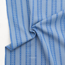 Load image into Gallery viewer, Close-up of blue and white striped fabric with 'Fabletum' branding.