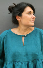 Load image into Gallery viewer, Woman wearing a teal dress against a gray background