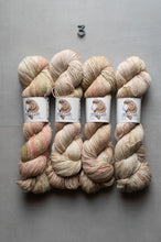 Load image into Gallery viewer, Four skeins of variegated yarn laid flat on a gray surface