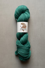 Load image into Gallery viewer, Teal skein of yarn with a label on a gray background