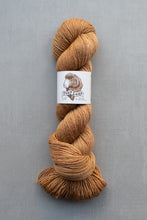 Load image into Gallery viewer, Brown skein of yarn with a label on a gray background