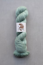 Load image into Gallery viewer, Green skein of yarn with a label on a gray background