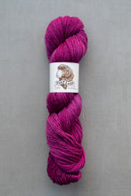 Load image into Gallery viewer, Purple skein of yarn with a label on a gray background