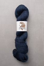 Load image into Gallery viewer, Blue skein of yarn with a label on a gray background