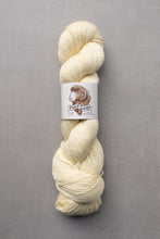 Load image into Gallery viewer, Cream-colored skein of yarn with a label on a gray background
