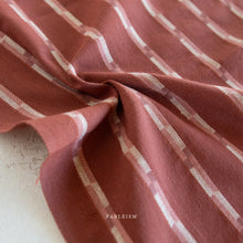 Load image into Gallery viewer, Close-up of red and white striped fabric with 'Fableism' branding.