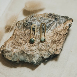 Pair of earrings on a textured stone surface