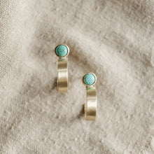 Load image into Gallery viewer, Pair of gold earrings with turquoise stones on a textured beige background