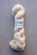 A single skein of cream-colored yarn with a white paper label reading 'Great Falls Montana' and 'A Montana Wool Co.' logo, photographed on a textured gray background.