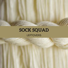 Load image into Gallery viewer, Close-up of beige yarn with 'Sock Squad Leftovers' label.