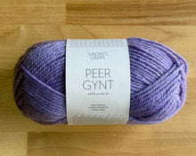 Load image into Gallery viewer, Purple yarn ball with a label on a wooden surface