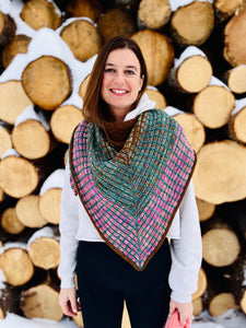 women wearing stitched scarf in front of log pile