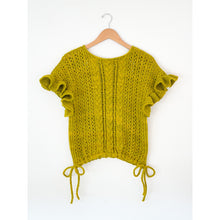 Load image into Gallery viewer, A yellow-green chunky knit short-sleeve top with ruffled sleeves and drawstring ties at the hem, hanging on a wooden hanger against a white background.