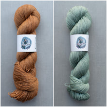 Load image into Gallery viewer, Two skeins of yarn, one brown and one green, on a gray background with labels.