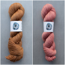 Load image into Gallery viewer, Two skeins of yarn, one brown and one pink, on a gray background with labels.