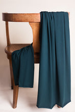 Load image into Gallery viewer, Teal fabric draped over a wooden chair on a plain background
