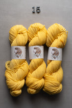 Load image into Gallery viewer, Three skeins of yellow yarn with labels on a gray background