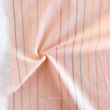 Load image into Gallery viewer, Pink fabric with multicolored stripes on a textured surface, featuring the brand 'Fableism'.