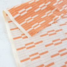 Load image into Gallery viewer, Close-up of fabric with orange and white geometric pattern on a white background