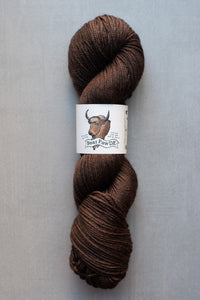 Brown skein of yarn with a label on a gray background