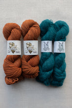 Load image into Gallery viewer, Four skeins of yarn arranged in two columns on a light gray textured background. The left two skeins are a warm rust orange, and the right two skeins are a deep teal blue-green.