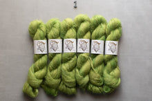 Load image into Gallery viewer, Six skeins of fluffy yarn in a light yellow-green shade, arranged side by side on a gray background. Each skein has a white paper label wrapped around it, and a small metal '1' is placed above the group.