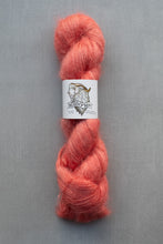 Load image into Gallery viewer, Peach-colored yarn skein with a label on a gray background