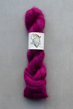 Load image into Gallery viewer, Fuchsia yarn skein with a label on a gray background
